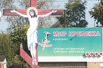 Распятый Иисус на фоне рекламы "Мир крепежа".
